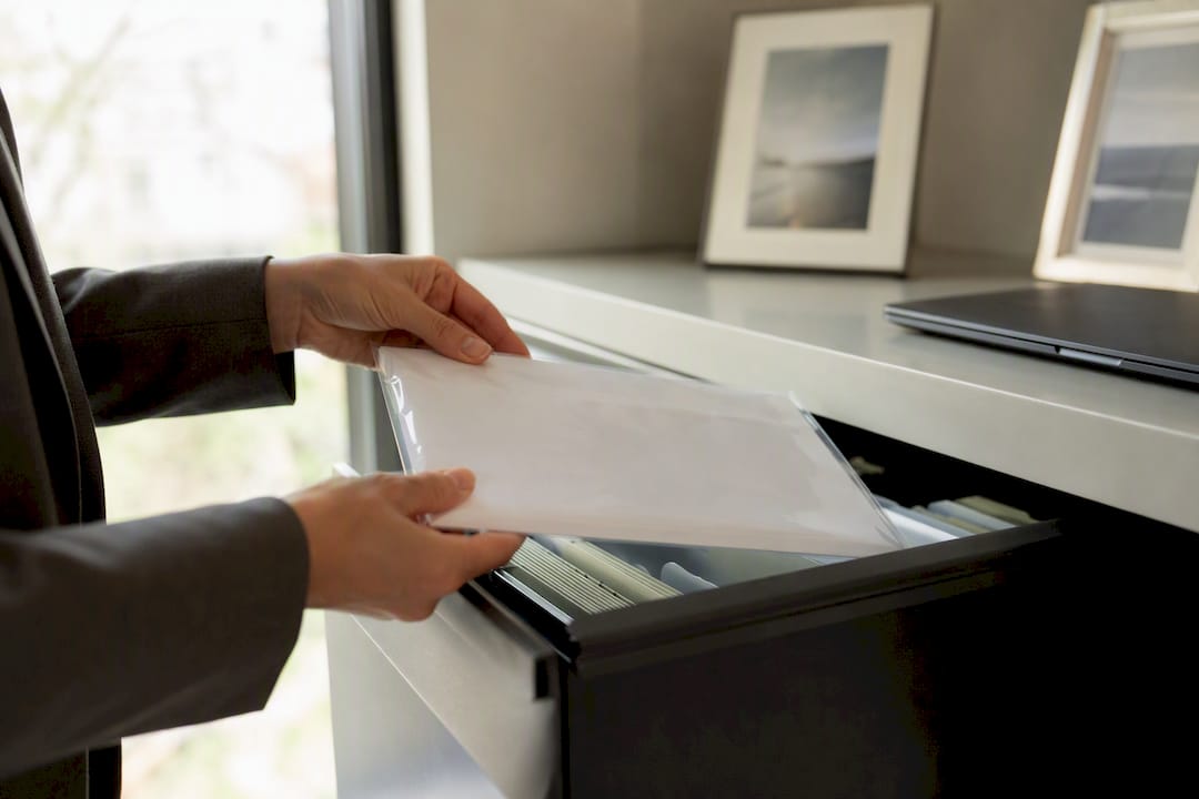 Escrow officer placing deposit envelope in drawer