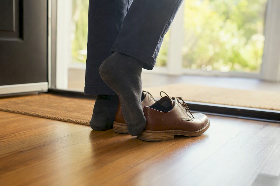 Guest removing shoes at open house entry