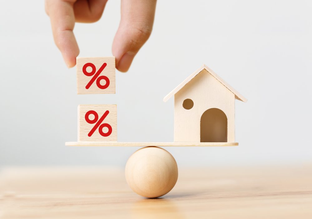 Interest rate, financial, and mortgage rate concept with a wooden home and coins